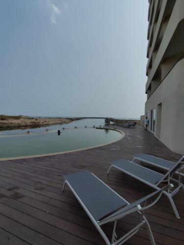 a couple of lounge chairs sitting on a deck next to the beach at Sol y mar in Boca del Río