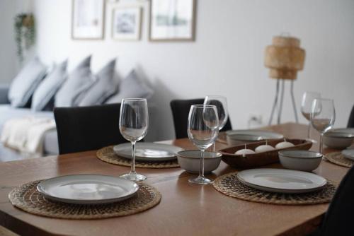 a wooden table with plates and wine glasses on it at HaKerem new luxury 3 rooms apartments and 2 rooms penthaus in Tel Aviv