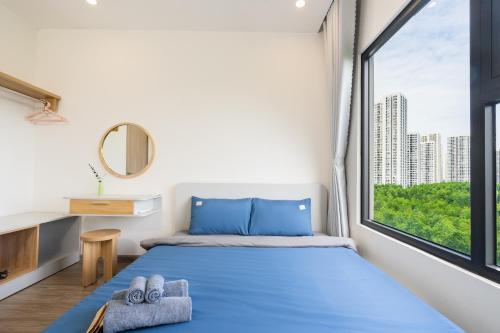 um quarto com uma cama azul e uma janela em Emma House 4 - Can ho 2PN Vinhomes Grand Park Quan 9 em Gò Công