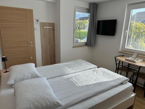 a bedroom with a bed and a table and window at Apartments Vidic in Bled