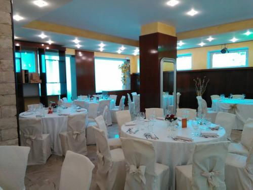 a banquet hall with white tables and white chairs at Hotel Tre Monti in Popoli
