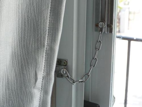 a chain attached to a window with a curtain at บ้านชมเขา - Baan Chom Khao in Pak Chong