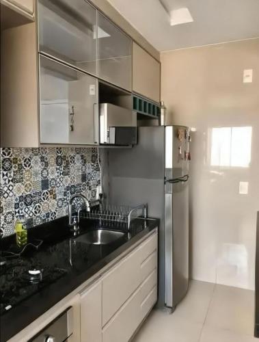a kitchen with a sink and a refrigerator at Apartamento bem localizado em fortaleza in Fortaleza