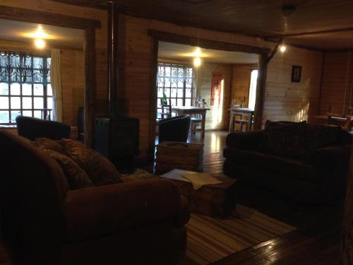 a living room with two couches and a fireplace at La Casa Escondida in Punta Arenas