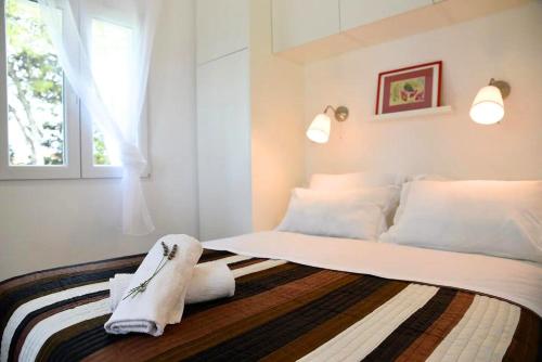 Un dormitorio con una cama con almohadas blancas y una ventana en Lili Sunset, en Stari Grad