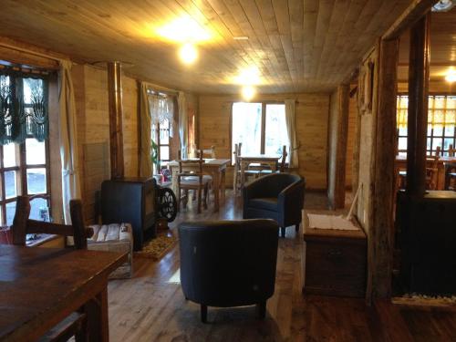 una habitación con sillas y mesas en una cabaña en La Casa Escondida, en Punta Arenas