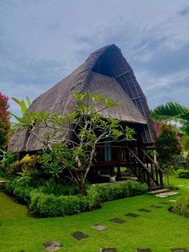 a thatch roofed house with a grass roof at Harta Lembongan Villas in Nusa Lembongan