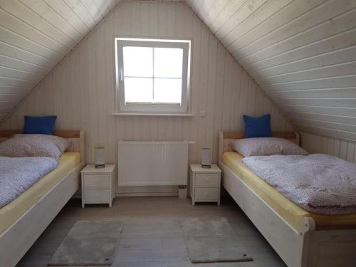 a attic room with two beds and a window at Beaver Modern retreat in Berg