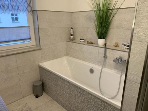 Villa Evi Modern retreat في لوبمين: حمام مع حوض استحمام مع نبات