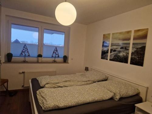 1 Schlafzimmer mit 2 Betten und 2 Fenstern in der Unterkunft Nelly Modern retreat in Horumersiel
