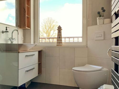 KührstedtにあるLandlust Comfortable holiday residenceのバスルーム(洗面台、トイレ付)、窓が備わります。