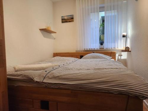 a bed sitting in a room with a window at Sound of the sea Modern retreat in Wangerooge