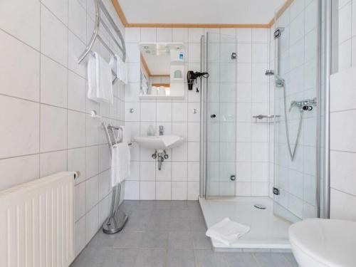 a white bathroom with a shower and a sink at Salweyblick Modern retreat in Niedersalwey