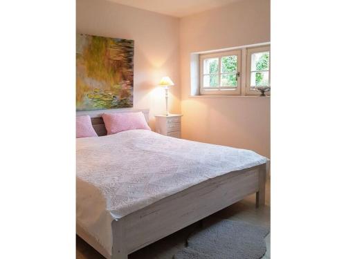 een slaapkamer met een bed en een raam bij Rose Cottage Comfortable holiday residence in Petershagen