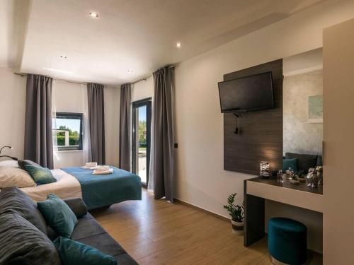 ein Hotelzimmer mit einem Bett und einem TV in der Unterkunft Villa Bella Vita in Barban