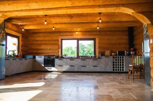 eine große Küche in einem Blockhaus mit einem Fenster in der Unterkunft The universe of Wood ! BranWood in Sohodol