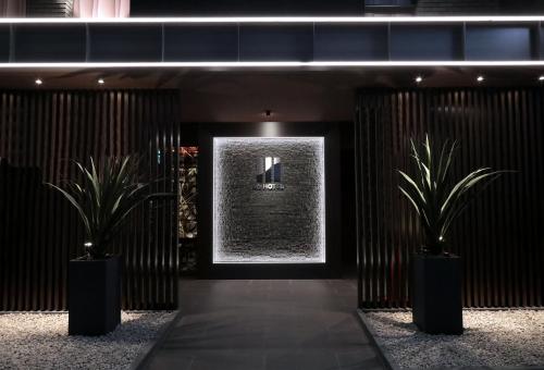 名古屋的住宿－M'z HOTEL，建筑里两棵盆栽的走廊