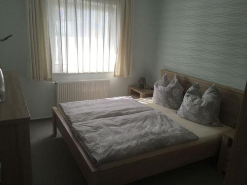 una camera da letto con letto, cuscini e finestra di Strandhus Modern retreat a Lubmin