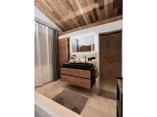 La salle de bains est pourvue d'un lavabo et d'un miroir. dans l'établissement Maja Chalets Comfortable holiday residence, à Seiwerath