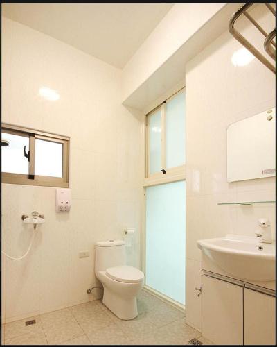 uma casa de banho branca com um WC e um lavatório em CHONG Kam Bed and Breakfast em Magong