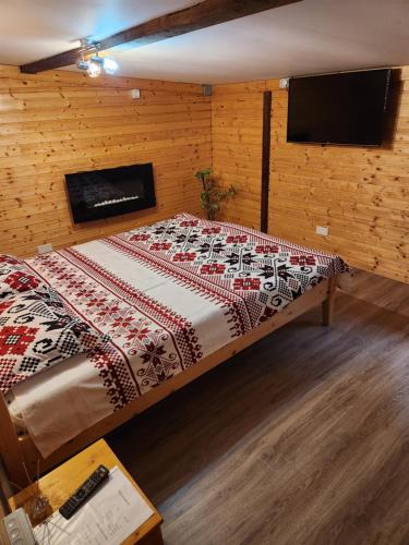 a large bed in a room with a tv at Refugiul Rustic in Arad