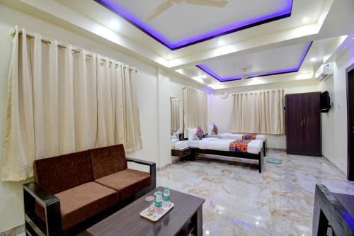 a living room with a couch and a bed at Anchorage Inn in Thākurdwari