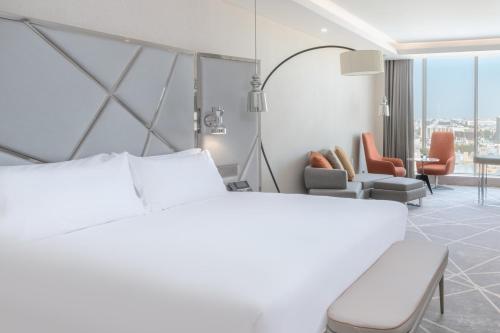 リヤドにあるクラウンプラザ ホテル リヤド ミナルのベッドとリビングルームが備わるホテルルームです。