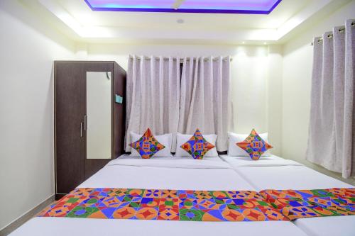 a bedroom with a large bed with colorful pillows at Anchorage Inn in Thākurdwari