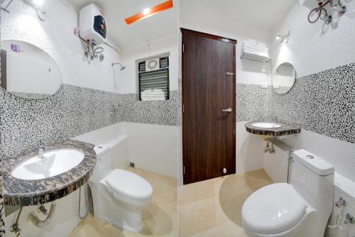 a white bathroom with a toilet and a sink at Anchorage Inn in Thākurdwari