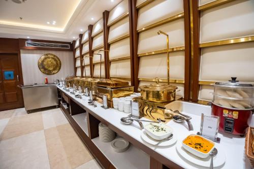 a kitchen with a long counter with many dishes at Arcadia Hotel in Varanasi