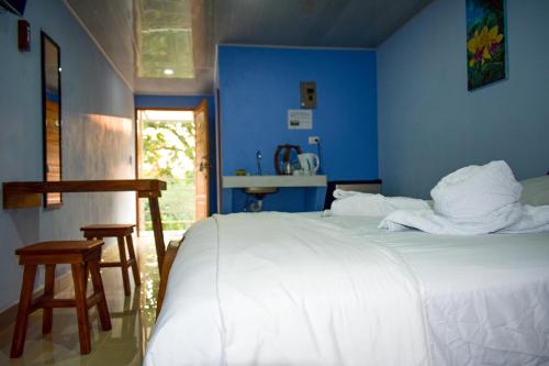 una camera da letto con un letto bianco e pareti blu di Cabinas Ecologicas Rio Brasil a Tabores