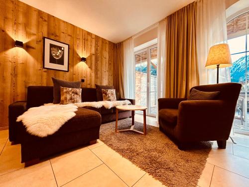 a living room with a couch and a chair at Sonn-Alm Chalet-Apartments in Bichlbach