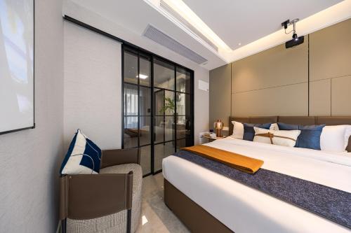 a bedroom with a large bed with blue and white pillows at Xi Ke Executive Apartment - Shenzhen Futian Exhibition Center in Shenzhen
