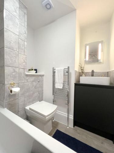 a white bathroom with a toilet and a sink at Campbells Crib in Kent