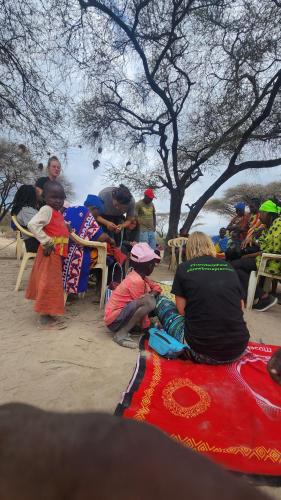 a group of people sitting on chairs under a tree at Janibichi Adventures hostel in Moshi