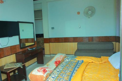 a bedroom with a bed and a desk and a television at Mount Heaven Hotel Murree in Murree