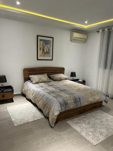1 dormitorio con 1 cama grande y 2 mesitas de noche en Pavillon bouchaoui en Cheraga