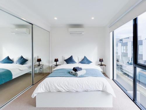 a bedroom with two beds and a large window at Modern 3-level Townhouse FreeParking in Melbourne
