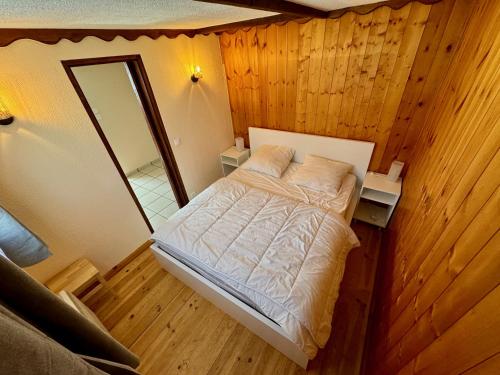 une petite chambre avec un lit et un miroir dans l'établissement L'étape du plateau de Corréo, à La Roche-des-Arnauds