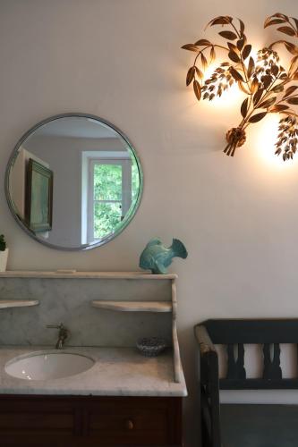 bagno con lavandino e specchio a parete di Chambre d'hôtes chez Johannes et Adèle a Brive-la-Gaillarde
