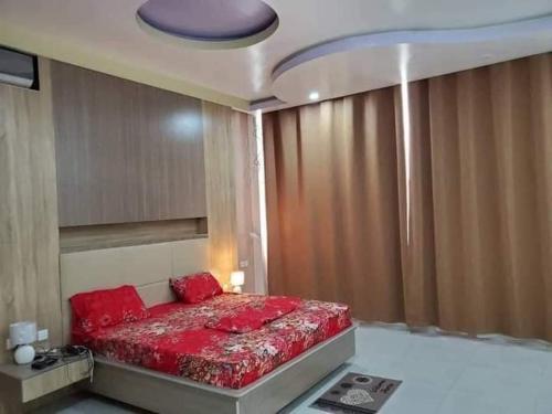 una camera da letto con un letto con cuscini rossi di Villa duplex meublée piscine à Akpakpa ciné concorde a Cotonou
