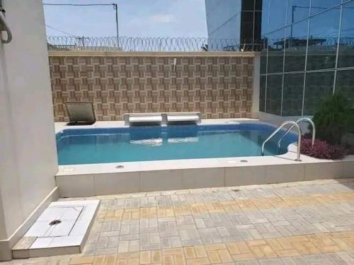 a swimming pool with a laptop on top of it at Villa duplex meublée piscine à Akpakpa ciné concorde in Cotonou