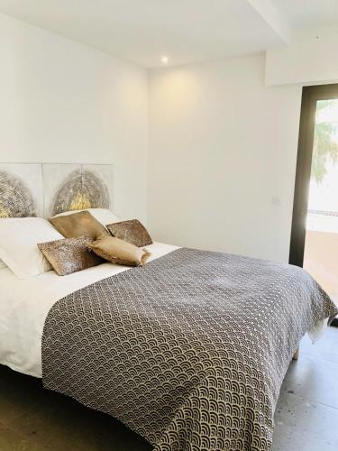 une chambre blanche avec un grand lit avec des oreillers dans l'établissement Appartement T3 lumineux traversant totalement neuf en face de la plage Front de mer vue sur les iles Vue mer panoramique assurée Résidence de la plage centre ville du Lavandou 3eme étage avec ascenseur Appartement T3, au Lavandou