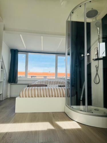 a bedroom with a bed and a large mirror at Hello Noordwijk - Zomerhuis Quarles van Uffordstraat in Noordwijk aan Zee