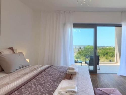 una camera da letto con un letto grande e una grande finestra di Esmeralda II Comfortable holiday residence a Novigrad Istria