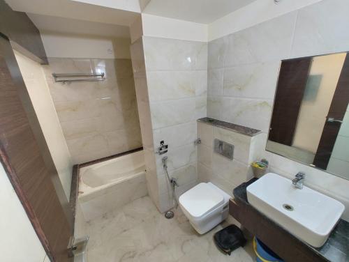 a bathroom with a sink and a toilet and a tub at Lijoy Hotel & Restra in Būndi