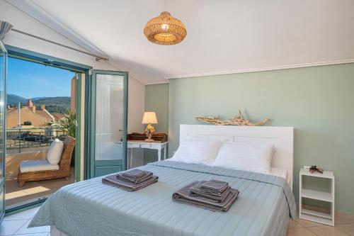 a bedroom with a bed with two towels on it at The Square Suites 2nd floor apartment in Argostoli