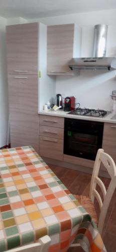 cocina con mesa y fogones horno superior en Olivo Bonsai, en Passignano sul Trasimeno