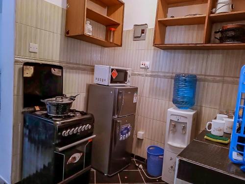 a kitchen with a stove and a refrigerator at Dasha Studio apartment Bamburi D4 in Bamburi