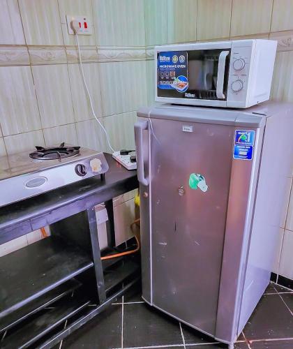 a microwave sitting on top of a small refrigerator at Dasha Studio apartment Bamburi D4 in Bamburi